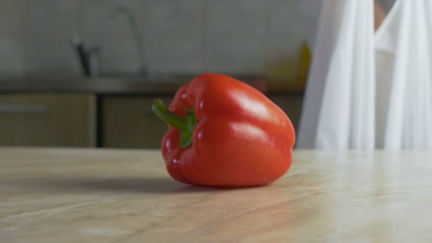 Чоловік ставить натуральні фермерські овочі на стіл на домашню кухню в повільному русі — стокове відео