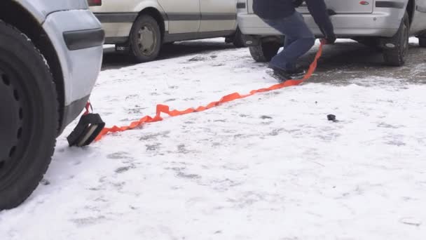 Człowiek łapie kabla ciągnącym na samochód holownik, zima, zvodka samochodu przy użyciu holownika, problem — Wideo stockowe