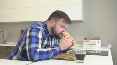 Ekose gömlekli sakallı şişman adam aşağı lokanta çizburger ve yıkama yiyor zararlı limonata, ekstra kalori, abur cubur, uyuşuk