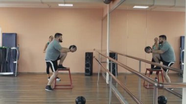 Kişisel eğitim için spor giyim büyük karın ile fatboy atletik kızdan. Şişman adam kadın öğretim üyesi ile eğitim ve fitness Center'da egzersizleri yapıyor. Kişisel birlikte kalın obez adam