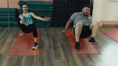 Kişisel ince Koç ile birlikte kalın obez adam fiziksel pislik içinde jimnastik salonu var. Kusursuz bir beden ile kilolu erkek ve kadın öğretim üyesi tarafından egzersiz kalori yakmak. Kişisel eğitim için atletik kız dan