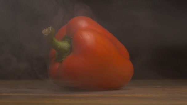 Roter frischer und saftiger bulgarischer Pfeffer auf schwarzem Hintergrund in Rauch, Verdunstung und Gemüse, Nahaufnahme, Zeitlupe — Stockvideo