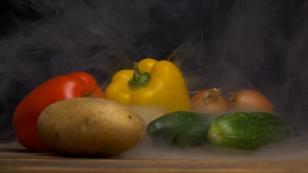 Verduras frescas pimienta búlgara, pepinos, papas y cebollas sobre un fondo negro de las verduras sopla fresco y fresco, primer plano, cámara lenta — Vídeo de stock