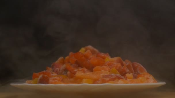 Тарілка з нарізаним замороженим перцем, який обертається і дме холодно, свіжість і жир, крупним планом, повільний рух, вегетаріанський — стокове відео