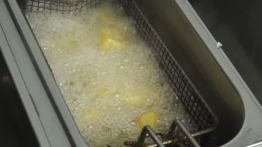 Yakın patates yavaş hareket, yağ kaynar ve kafeler mutfakta slowmo pişirme Patates kızartması, yağlı fast food için ayçiçeği veya bitkisel yağ yeniden bir restoranda derin fritöz kızartılır
