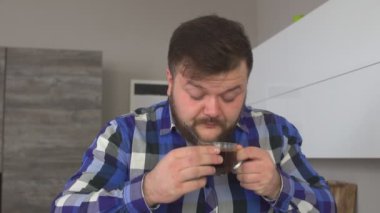 Bir fincan kahve onun el ve canlandırıcı kahve aroması, yakın çekim, ağır çekim sniff sakallı uykulu adam tutar