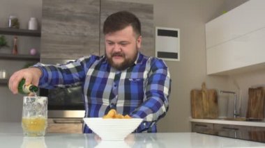 Sakallı bir adam onun bira cam mutfak bir bira dökülen, orada yanında cips, abur cubur, ağır çekim, zevk vardır