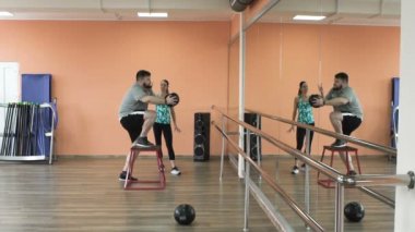 Kusursuz bir beden ile kilolu erkek ve kadın eğitmen tarafından egzersiz kalori yakmak. Kişisel eğitim için spor giyim büyük karın ile fatboy atletik kızdan. Şişko kadın öğretim üyesi ile eğitim