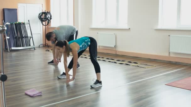 Allenamento personale da ragazza atletica per ciccione con grande addome in abbigliamento sportivo. Allenamento uomo grasso con istruttrice donna e fare esercizi nel centro fitness. spesso obeso ragazzo insieme con personale — Video Stock