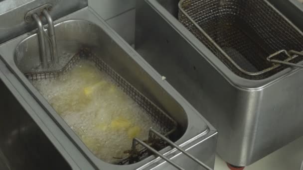 Кипящее масло во фритюрнице, в которой картофель в стиле кантри, фаст-фуд, замедленное движение — стоковое видео