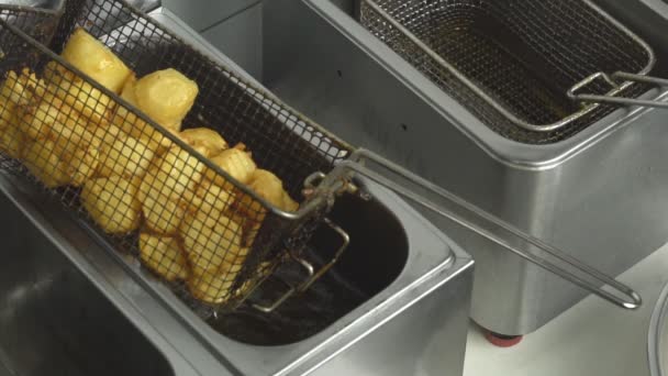 Жареный картофель с золотой корочкой, приготовленный во фритюрнице с большим количеством масла. нездоровую и жирную пищу холестерина, медленный мо — стоковое видео