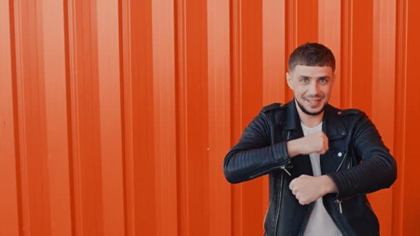 Cheerful happy man moves dances and sings against the orange background — Stock Video