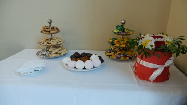 Mesa festiva com biscoitos e doces e flores frescas, câmera lenta, decoração — Vídeo de Stock