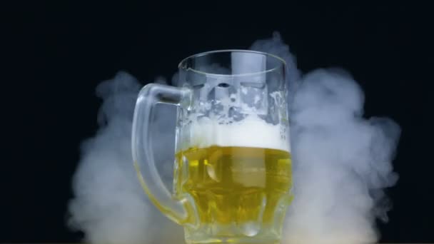 poloviny plná sklenice Plzeňského nebo ležák pivo točí v kouři v pomalém pohybu