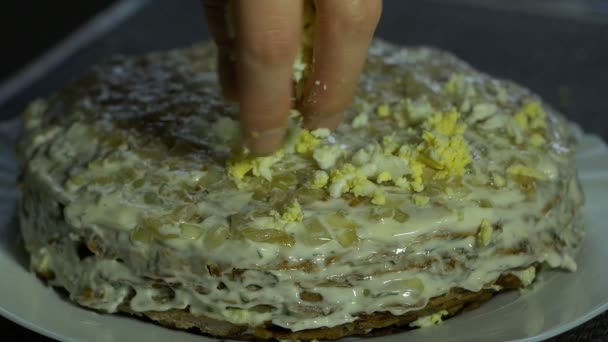 Uma menina prepara um bolo de fígado para o feriado e coloca um ovo cozido em camadas de bolo de fígado, close-up, slow mo. — Vídeo de Stock