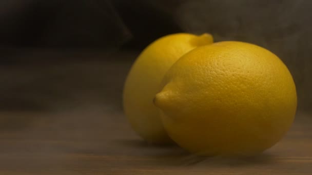 Fresh lemons on a black background from which blows freshness and coolness, evaporation, close-up, slow motion, copy space — Stock Video