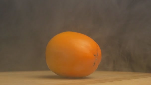 Rotierende reife Persimmon, aus der Frische und Kühle auf schwarzem Hintergrund weht, Nahaufnahme, Zeitlupe, Früchte — Stockvideo
