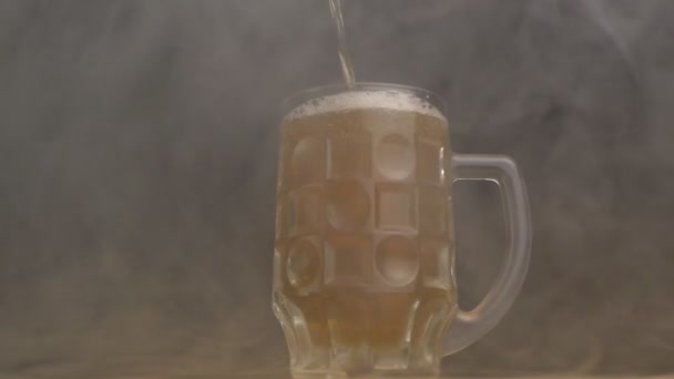 Verdrehtes Bierglas, in das frisches Bier im Dunst gegossen wird, Nahaufnahme, schwarzer Hintergrund, Zeitlupe — Stockvideo