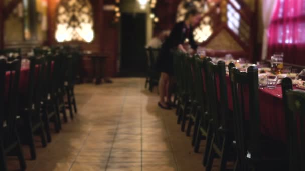 Camarera organiza platos de comida en la mesa en el restaurante para la cena corporativa, sala de banquetes — Vídeos de Stock