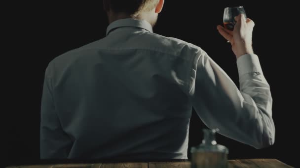 Concept van anonieme alcoholische en alcoholisme of alcohol gebruik stoornis, man zit met zijn rug naar de camera — Stockvideo