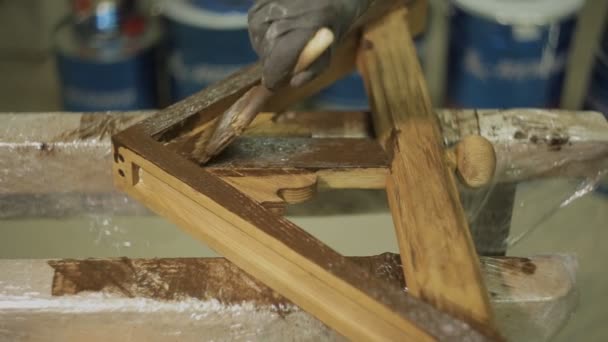 Arbeiter mit Pinsel bemalt ein Holzprodukt oder einen Möbelteil — Stockvideo