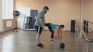 Kişisel ince Koç ile birlikte kalın obez adam fiziksel pislik içinde jimnastik salonu var. Kusursuz bir beden ile kilolu erkek ve kadın eğitmen tarafından egzersiz kalori yakmak. Kişisel eğitim için atletik kız dan