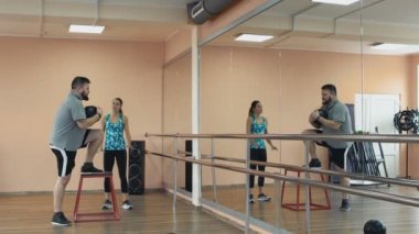 Şişman adam kadın öğretim üyesi ile eğitim ve fitness Center'da egzersizleri yapıyor. Kişisel ince Koç ile birlikte kalın obez adam fiziksel pislik içinde jimnastik salonu var. Kilolu erkek ve kadın eğitmen ile