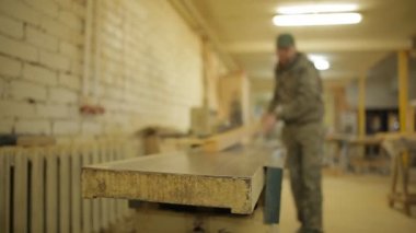 Üstünde a özel makine, makine kurulları planlama bir testere bankta bir işçi çalışıyor