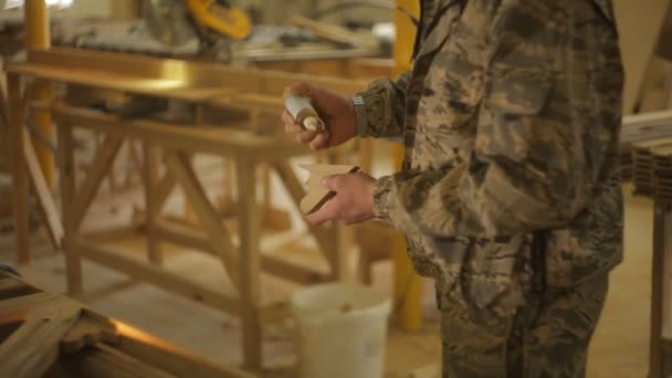 Tesař na pilu se vztahuje lepidlo na dřevěné části, dále montáž dřevěných výrobků, dělník — Stock video