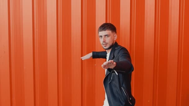 Sexy Kerl mit Schnurrbart tanzt gegen die orangefarbene Wand, Konzept menschliche Emotion — Stockvideo