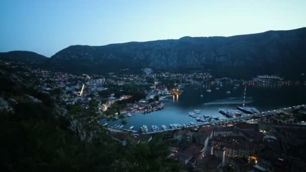 Panoramisch uitzicht over toeristische badplaats Kotor met haven en haven, mooie avond landschap met de zee en het eiland in Montenegro als een Italië of Kroatië — Stockvideo