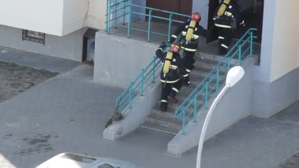 Группа пожарных бежит в дом, чтобы эвакуировать людей и потушить пожар, профессионально — стоковое видео
