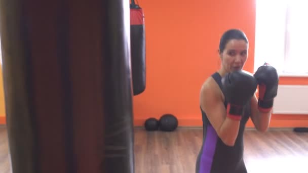 Ragazza carina boxe un sacco da boxe in allenamento in palestra, muscolare — Video Stock