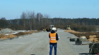 Arazi veya Şef inceler ve yol kaldırım malzeme veya platform ağır inşaat ekipmanları tarafından döşeme önce bina bir aşamasında bilgi yazıyor
