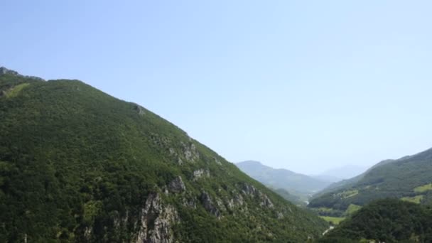 Панорамный вид на красивую природу с зелеными горами с деревьями и голубым небом в Черногории, как Италия или Хорватия — стоковое видео