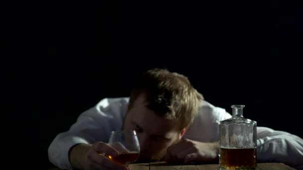 Smutný muž podnikatel s bradkou se dívá na láhev alkoholu, alkoholismus, černé pozadí, problémy — Stock video