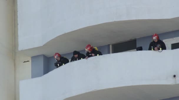Пожежна команда стоїть на балконі з палаючого будинку після гасіння пожежі, 21.02.19 Бобруйськ, Білорусь — стокове відео