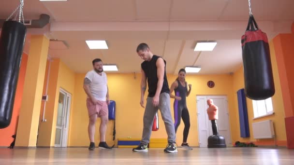 Πυγμαχία και πολεμικές τέχνες, ένας άντρας και ένα κορίτσι που εκπαιδεύονται από έναν εκπαιδευτή σχετικά με τις τεχνικές της σταθερότητας για τους πόδια, αργή κίνηση, Καυκάσιος, τον τρόπο ζωής — Αρχείο Βίντεο