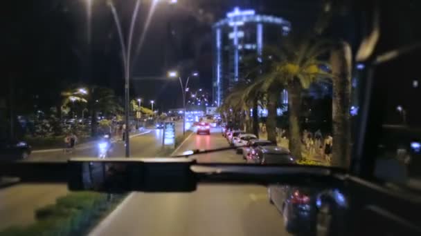 Vista a través de parabrisas de autobús que viajan en la calle de la carretera de noche en la ciudad turística — Vídeo de stock