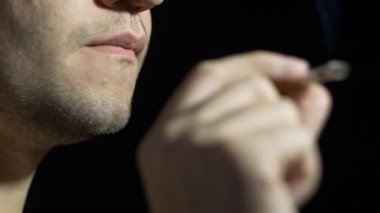 tıraşsız özensiz adam sigara, yakın çekim, siyah arka plan, hasar, ağır çekim