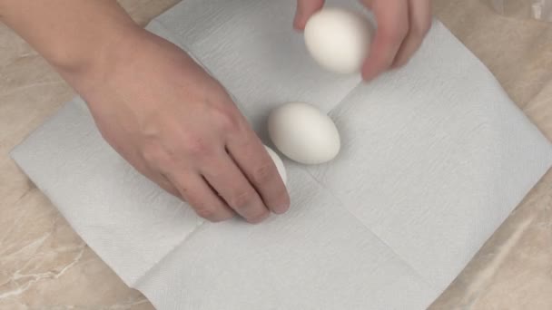 A man lays on the table white prepared chicken eggs for painting for the holiday Easter, hand, happiness — Stock Video