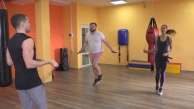 Sakallı adam ve kız bir eğitmen, boks, ip atlama eğitimi önce ısınmak gözetiminde spor salonunda bir ip atlama