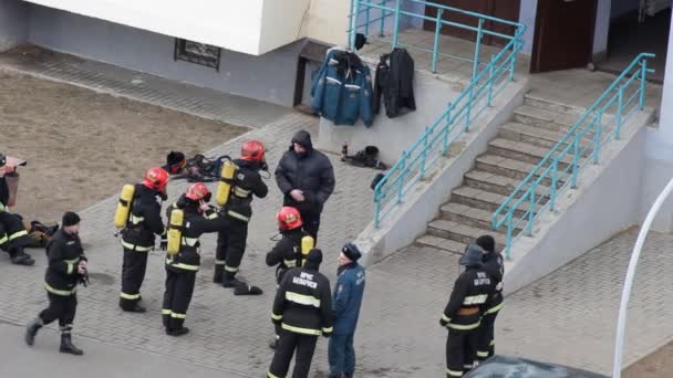 Пожарная группа вбегает во вход, чтобы устранить риск пожара, БОБРУЙСК, БЕЛАРУС 27.02.19 — стоковое видео