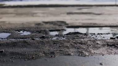 Bozuk yol ve asfalt çukurları ile su birikintileri. kötü yol yüzeyi sürüş ars
