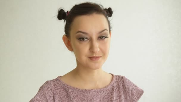 Porträtt av en leende flicka med bruna ögon och långa lösögonfransar. Härlig kvinnlig modell med snygg makeup på vit bakgrund — Stockvideo