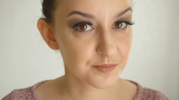 Mädchen mit langen Wimpern und braunen Augen macht Luftkuss. niedliches weibliches Modell mit modischem Make-up auf weißem Hintergrund — Stockvideo