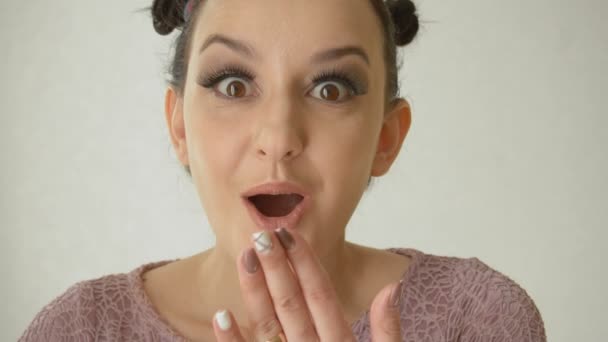 Porträtt av en förvånad flicka med bruna ögon och långa lösögonfransar. Söt modell med fashionabla makeup på vit bakgrund — Stockvideo