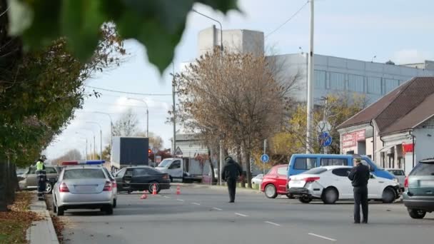 Les agents de la circulation de la police ou les flics travaillent sur un accident de la circulation ou CVM. L'éclairage d'urgence d'un véhicule clignote sur une voiture de patrouille avec une barre lumineuse rouge et bleue. Scène de crime ou vol — Video