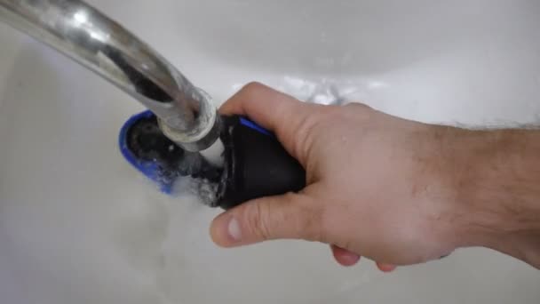 男性在早晨在水池或洗脸盆中清洗剃须的电旋转剃须刀 — 图库视频影像