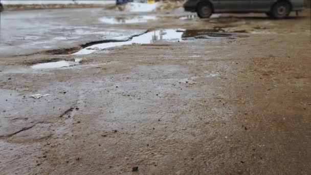 Bozuk yol ve asfalt çukurları ile su birikintileri. kötü yol yüzeyi sürüş ars — Stok video